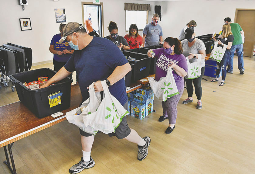 Volunteers and members of the Rotary Club of Yelm bag food on Sunday, July 12, at the Yelm Senior Center for the Rotary's "10 Weeks of Summer Lunch Program."