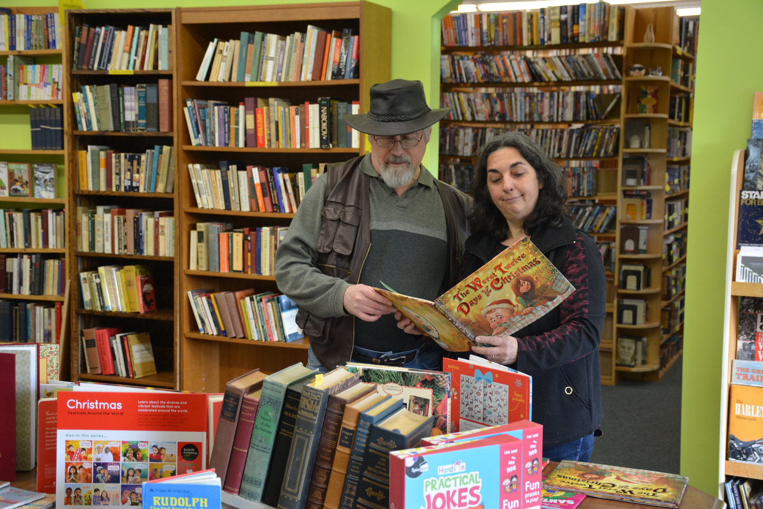 Janice Maddox reads a Christmas book to her husband, Robert, in their newly expanded bookstore.