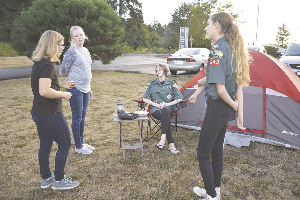 From left, Taylor Thomas, Emmalyn Shumaker, Hailey Van Elsacher and Colleen Fanning relax near the tent that was on display at at the Scouts BSA informational night at 9010 320th St. S., Roy.