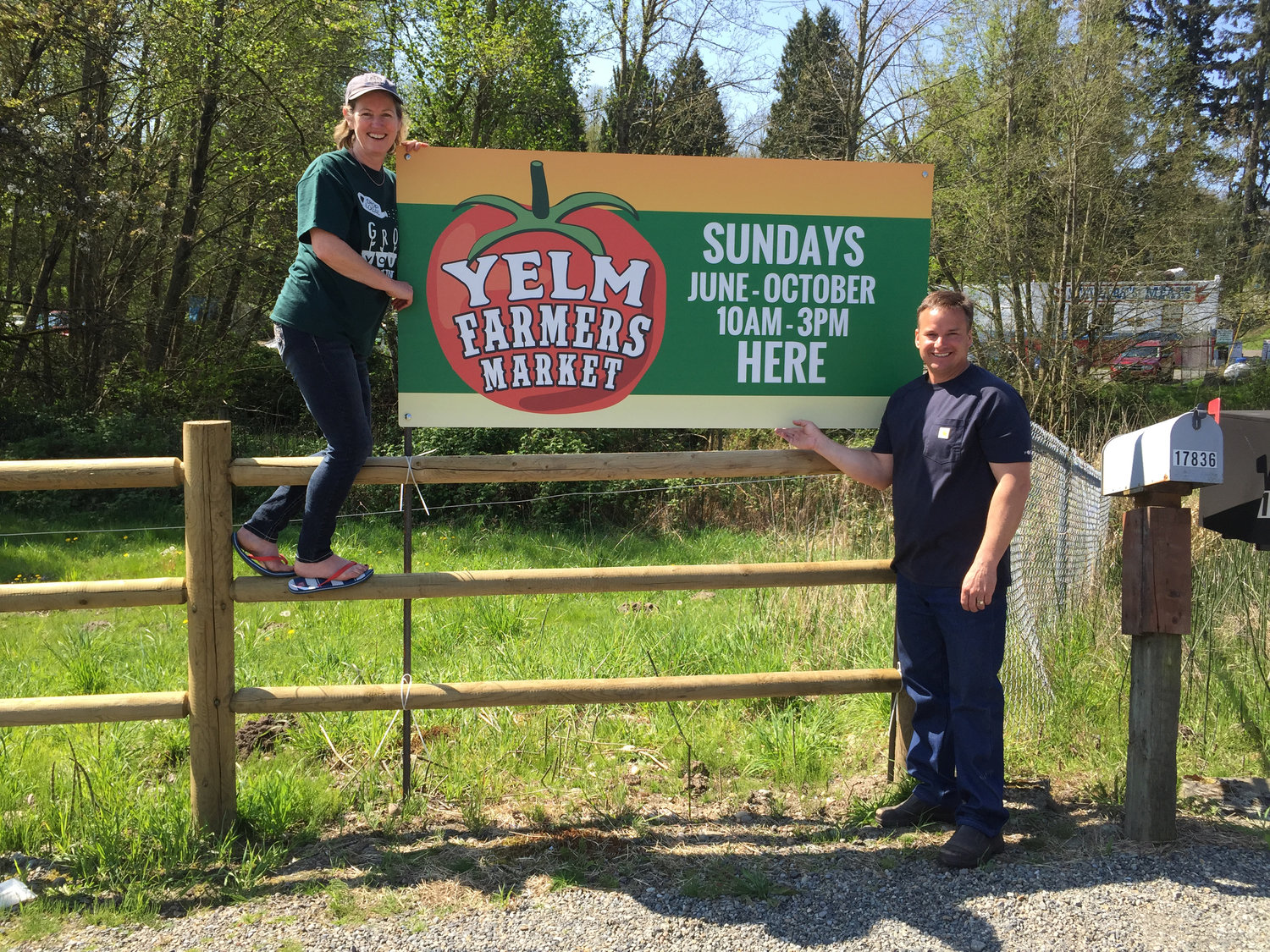 Yelm Farmers Market Manager Karen Rae, left, and Glenn Schorno, right, who owns the property where the market is held, show off a new signs set up in preparation for opening day on Sunday, May 31.