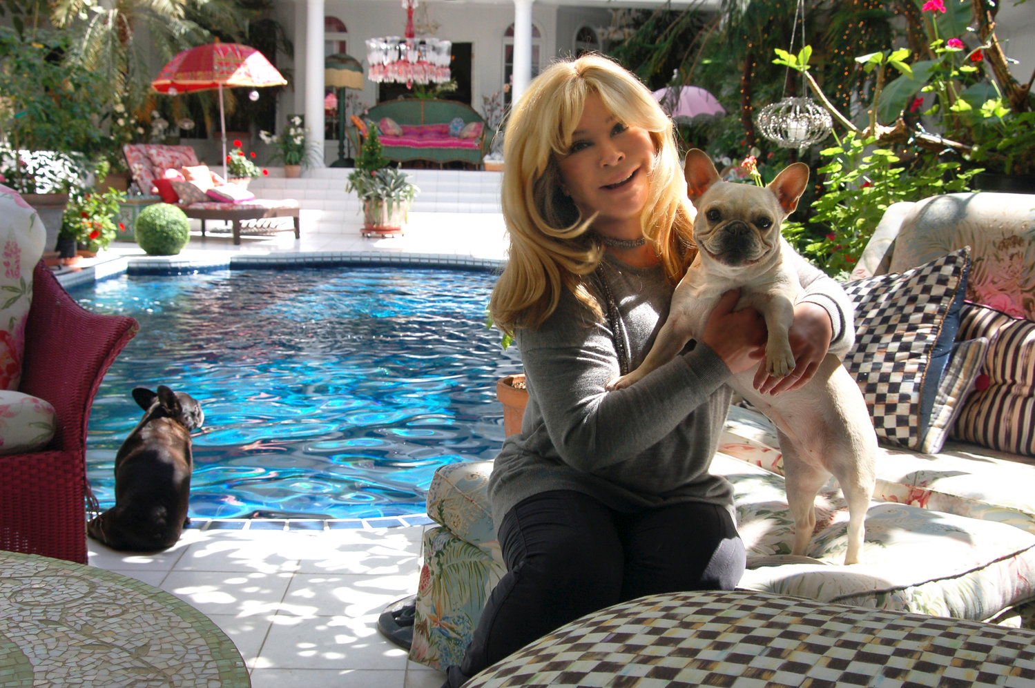 JZ Knight relaxes with her dog at her pool inside her home on the grounds of the Ramtha's School of Enlightenment. Knight, who says she channels the 35,000-year-old Ramtha, is turning over day-to-day operations of her business JZK Inc. to a board of directors.