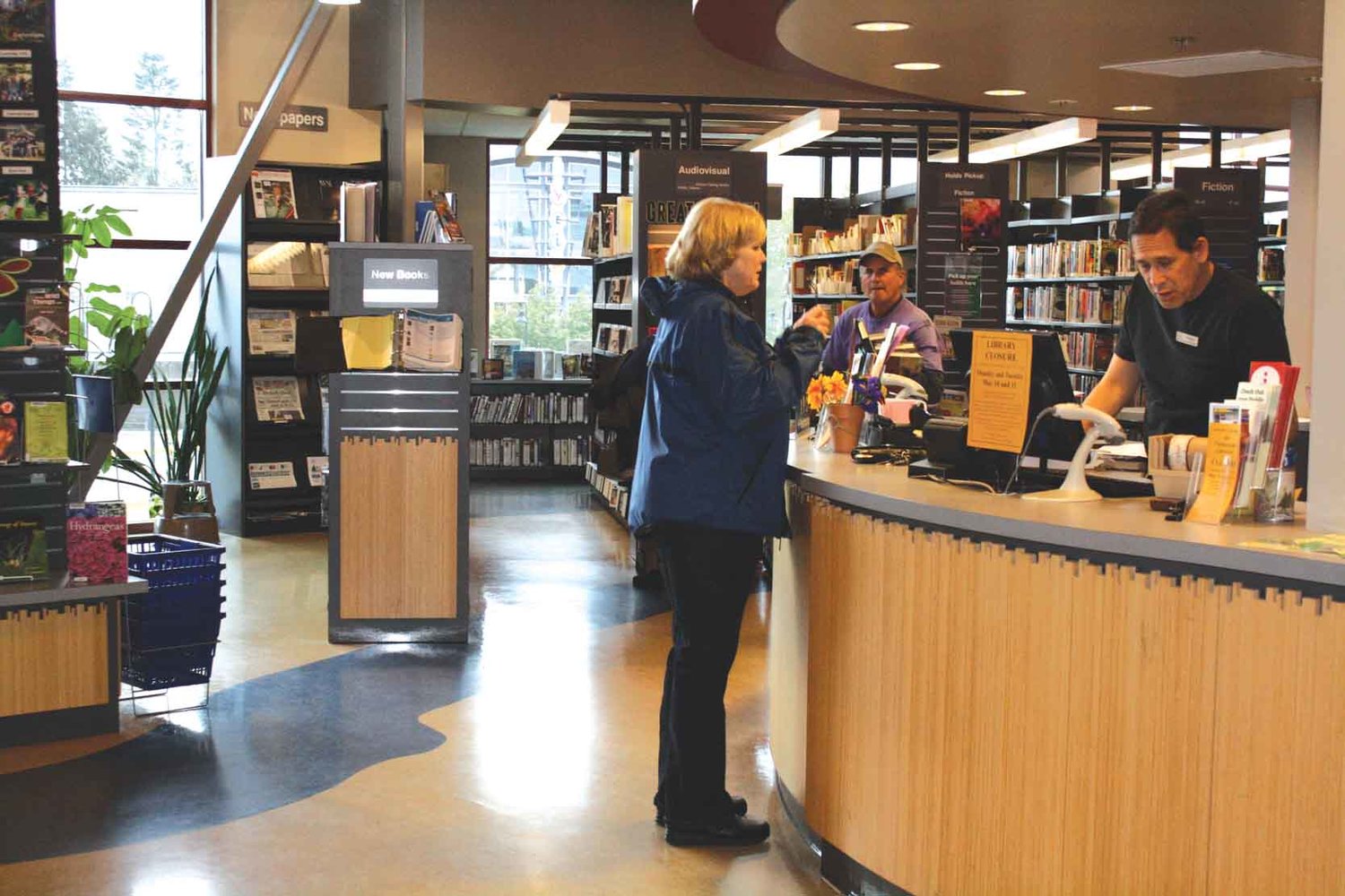 A person helps a patron at Yelm Timberland Library in this file photo.
