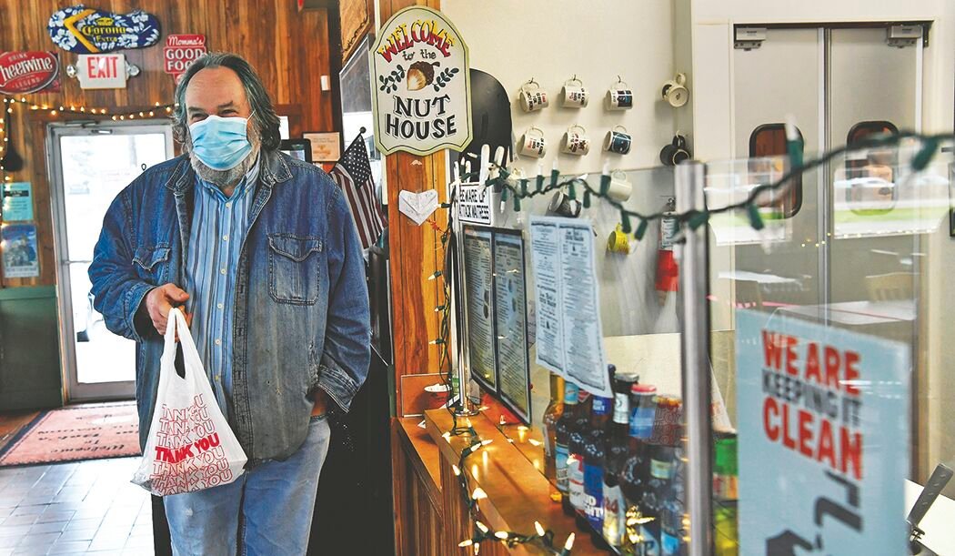 Roy resident Fred Kistenmacher gets ready to head outside on Tuesday, Nov. 24, after picking up a take-out lunch at Jim Bob's Chuck Wagon restaurant in Roy.