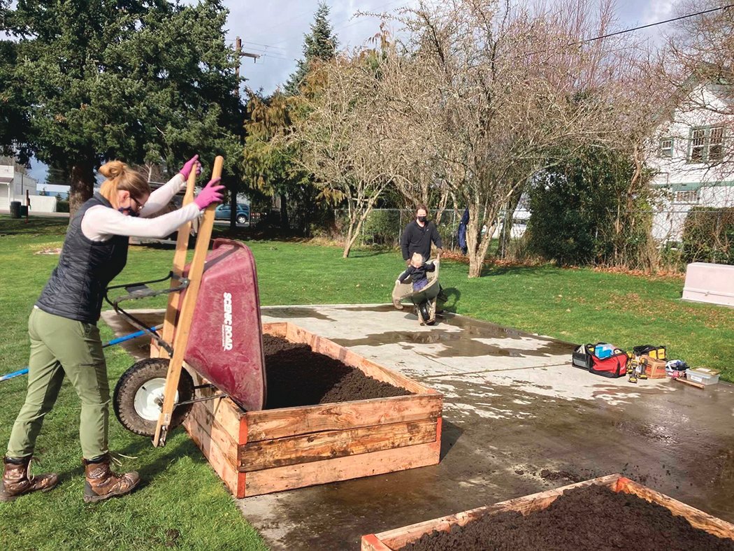 Crystal Buchholz of Rogue Permaculture & Resilient Veterans unloads a wheelbarrow during a community garden work party.