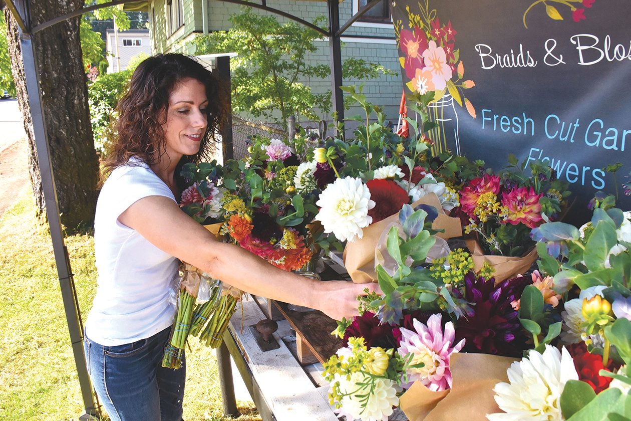 Tabatha Sand, owner of Braids and Blossoms Flower Farm, puts out bouquets on he farm stand located at 396 Sussex Ave. E. in Tenino.