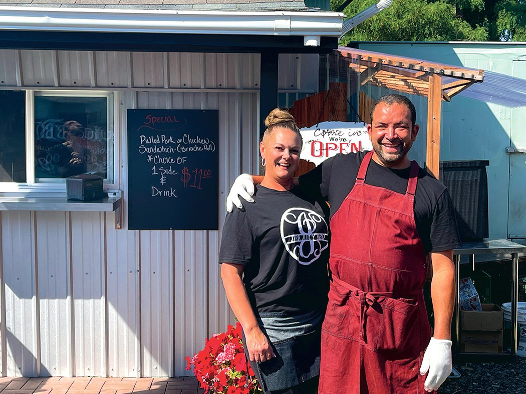 Jerk Juicy BBQ owners Brian Pillsbury and Debbie Wilson show off the new pick-up window at the back on Yelm Floral, where customers can order barbecue each day, while supplies last.