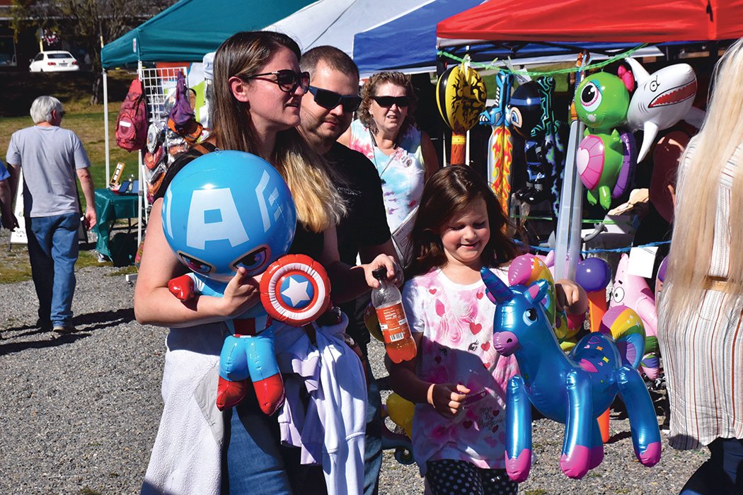 A family carries toys during the Yelm Fall Harvest Festival on Saturday, Sept. 25 at Yelm City Park.