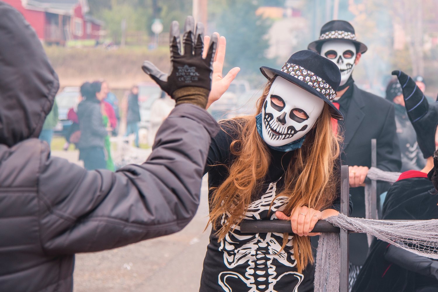 Skeletons and ghouls exchange high-fives during the Casket Parade Saturday afternoon in Bucoda.