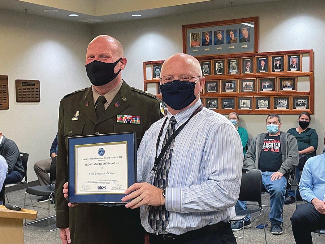 Yelm Community Schools Superintendent Brian Wharton accepts an award from the Washington National Guard.