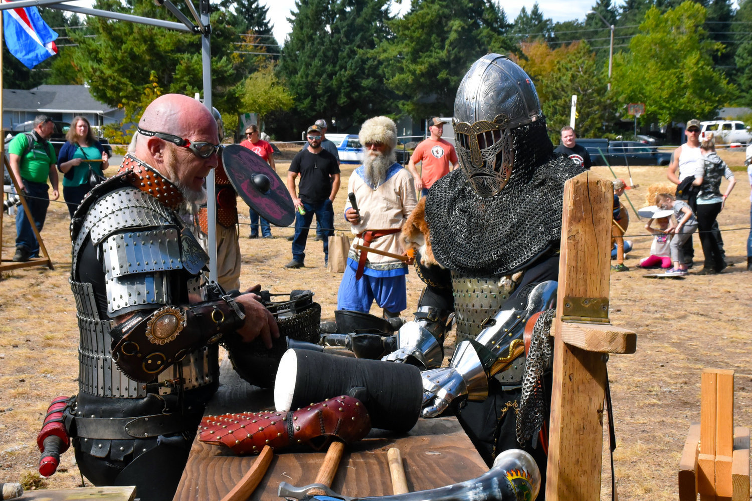 William Koutrouba, left, the organizer of the NorseWest Viking Festival which was held at Wilkowski Park on Sept. 11-12, 2021, dons some armor to participate in swordfighting following a poker run in honor of those affected by the events of Sept. 11, 2001.