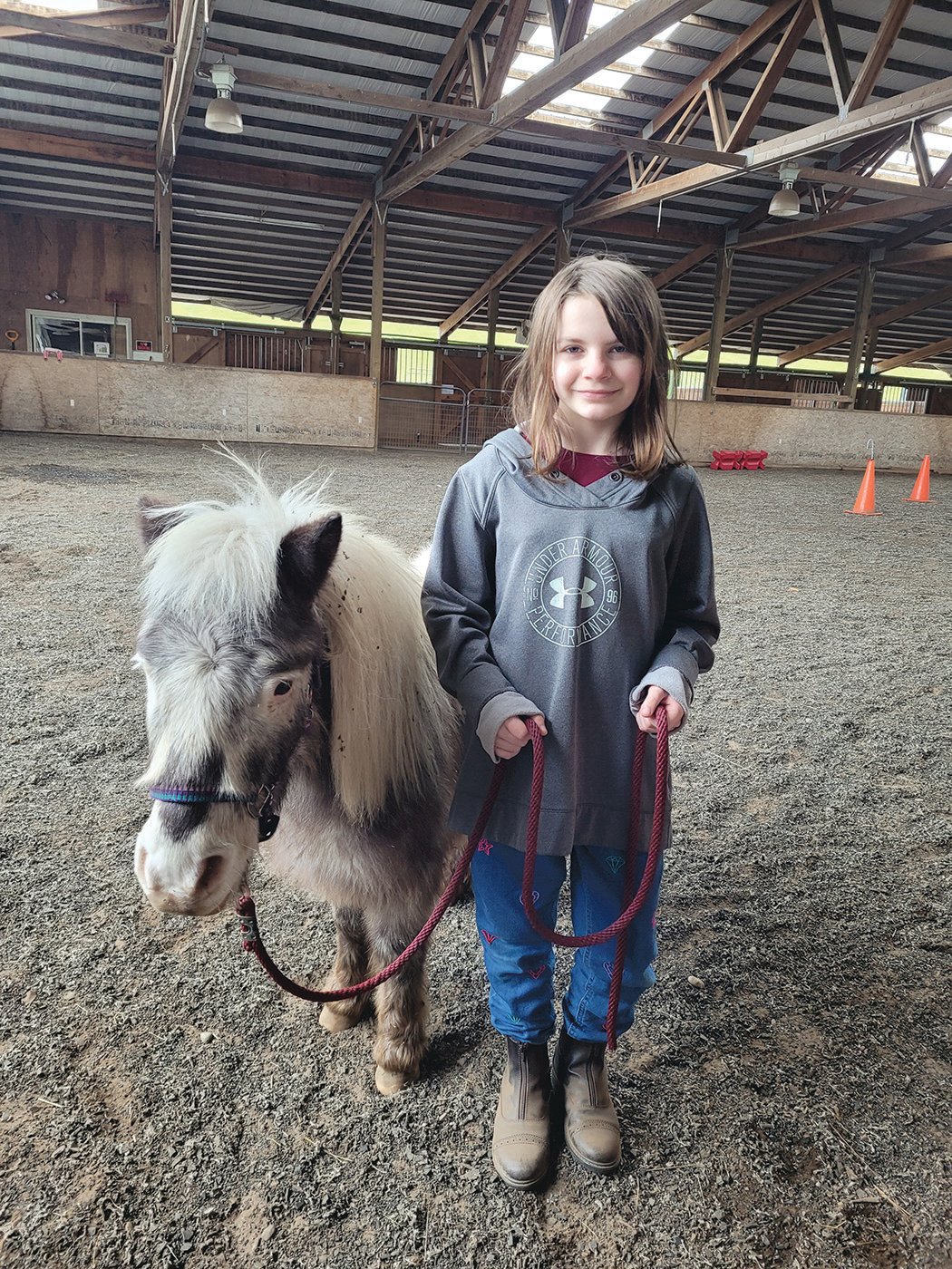 Nine-year-old Mackenzie Merkel poses with a mini-horse named Ghost.
