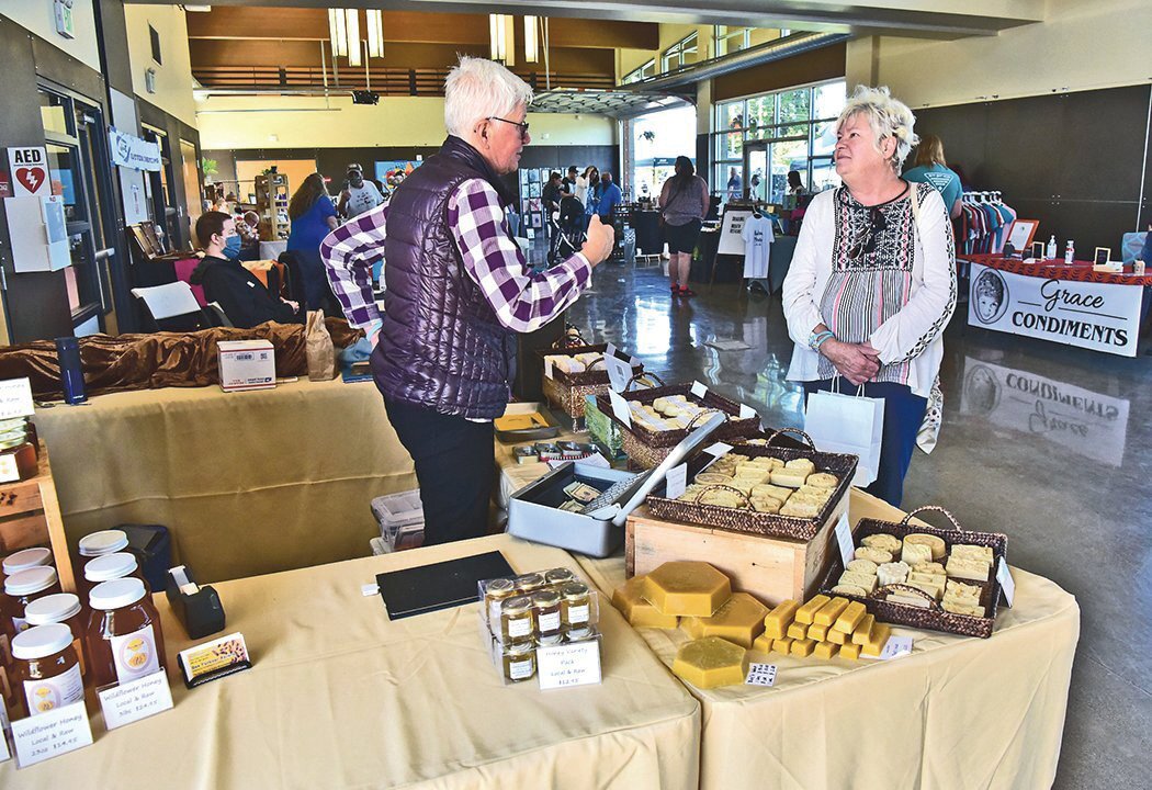 Puyallup resident Connie Diffenderfer, 70, right, chats with Karla Broschinski — an owner of Yelm-based Bee Forever Apiary — at previous Yelm Farmers Market on Saturday, May 29 at the Yelm Community Center.