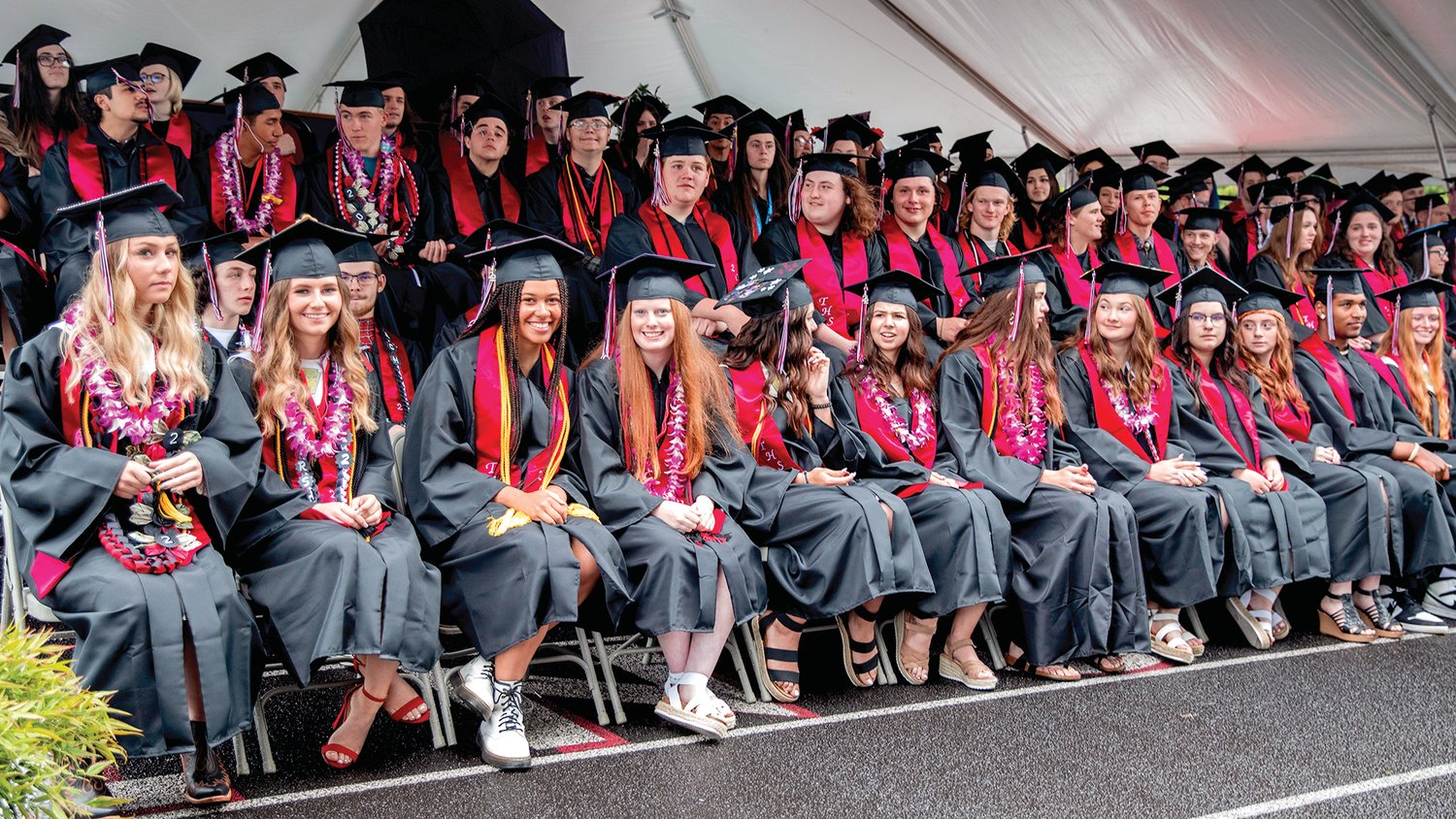 Graduates sit and smile through technical difficulties during a Tenino High School graduation ceremony on Friday.