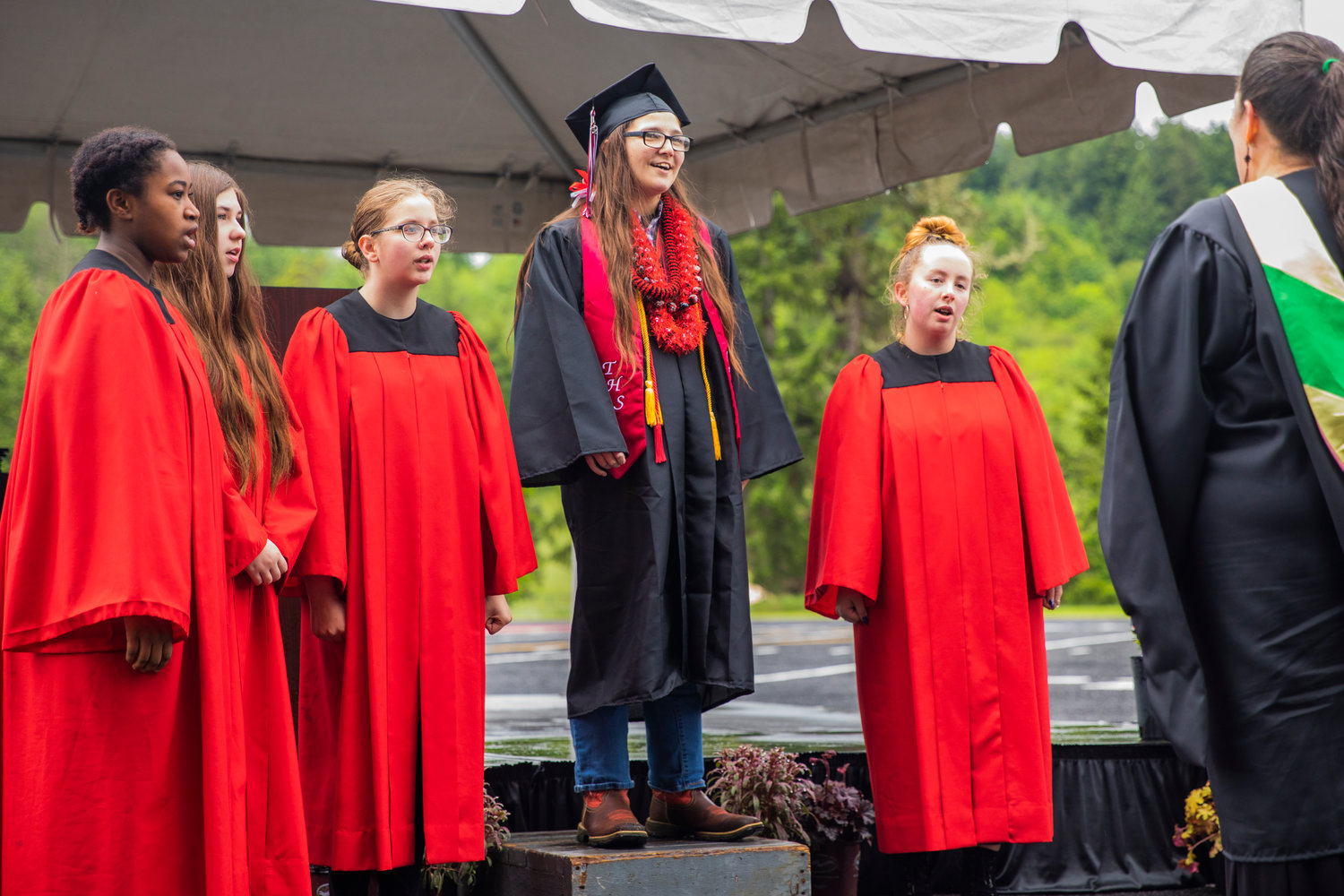 A graduate sings with the Tenino High School choir at Beaver Stadium on Friday.