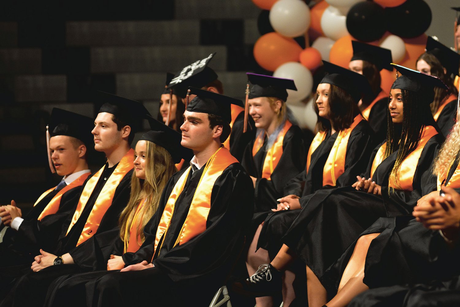 Members of Rainier’s 2022 graduating class watch on as a video plays at the commencement ceremony on June 10.