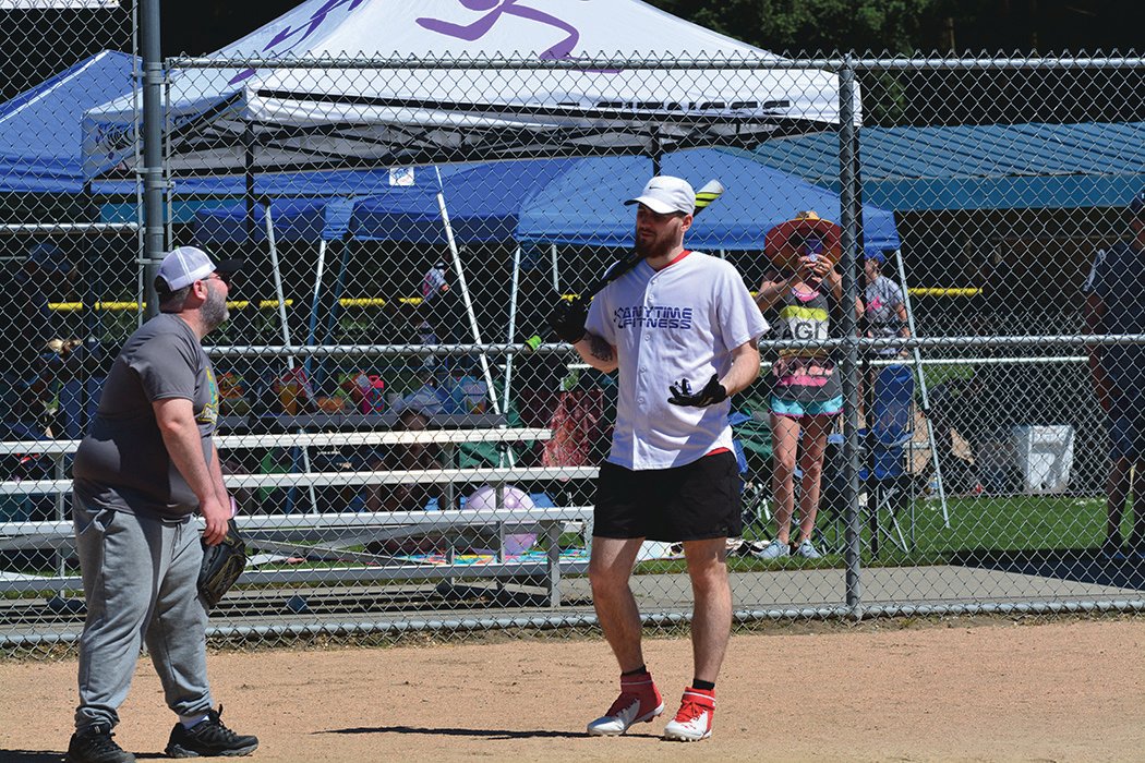 A member of team Anytime Fitness banters with the catcher on the opposing team on Sunday, June 26.