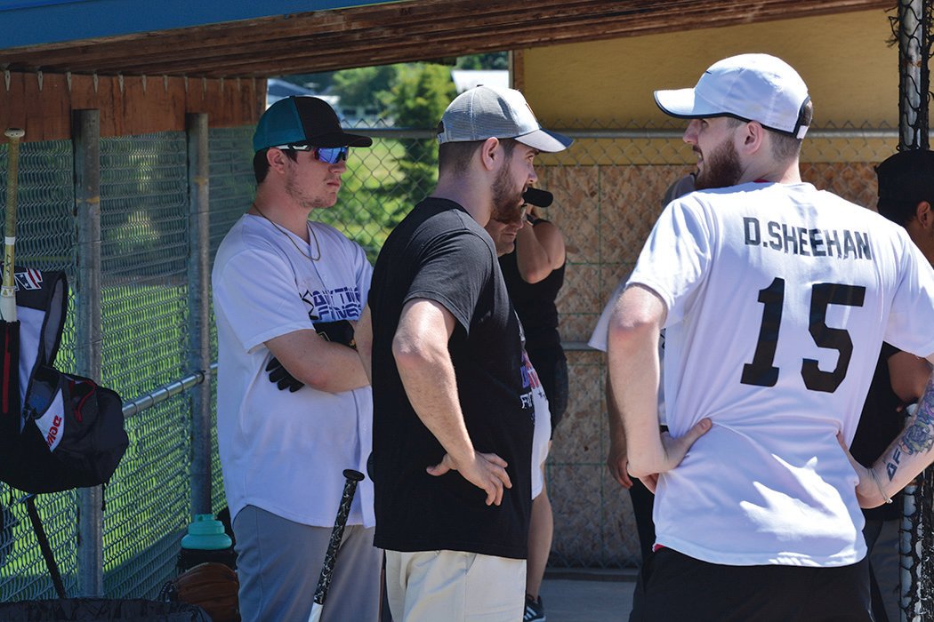 Team Anytime Fitness discusses strategy in their dugout during the second annual mushball tournament at Longmire Park on Sunday, June 26.