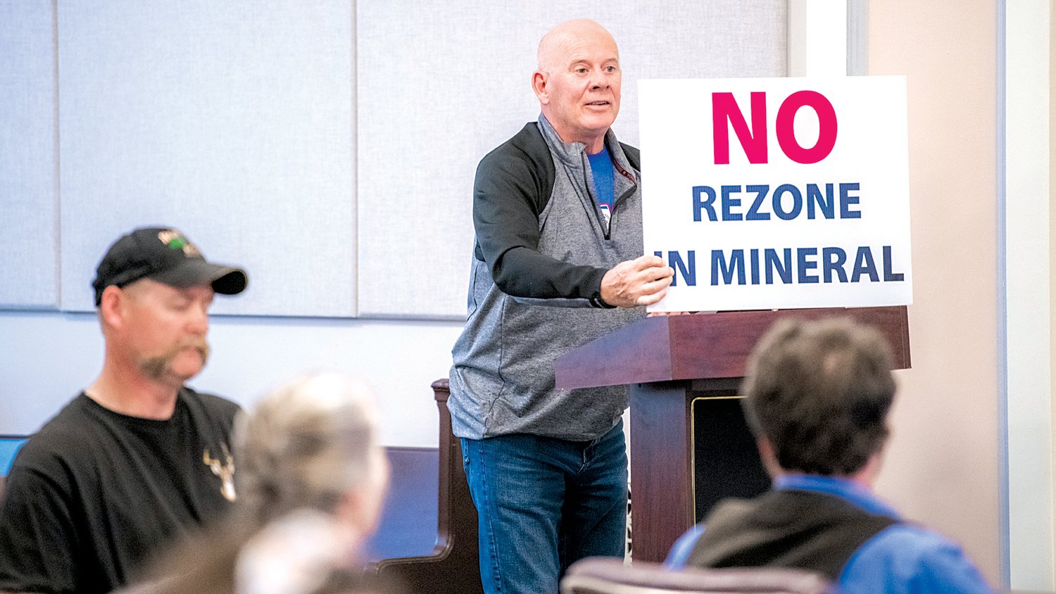 Mike Heinz holds a sign during a public hearing held by the Lewis County Planning Commission at the Lewis County Courthouse in Chehalis on Tuesday evening on a rezone proposal north of Mineral Lake.