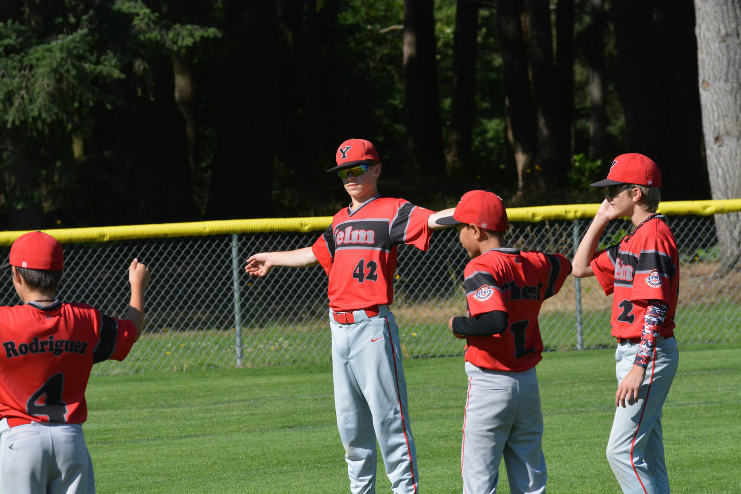 Four members of the Nisqually Basin 12U Yelm All Star team loosen up their shoulders before practice begins.