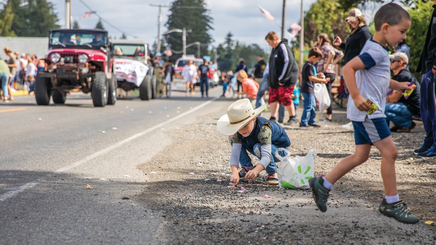 Patrick Thomas, 7, of Rainier, sports a cowboy hat while picking up candy during the Round Up Days parade Saturday morning.
