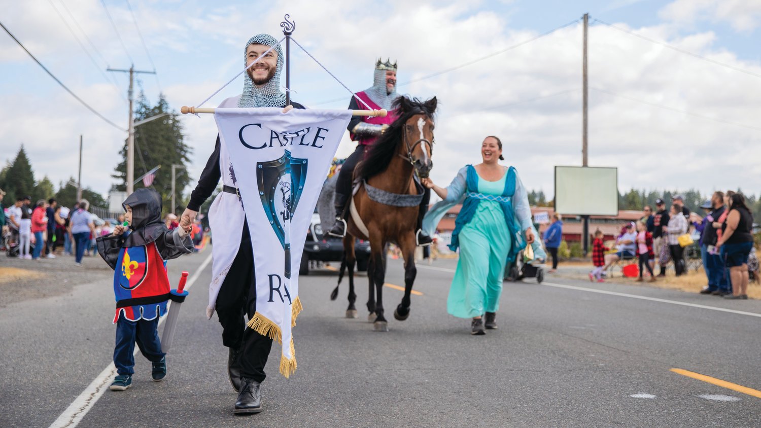 Employees at Castle Reality sport chain mail during the Rainier Round Up Days parade Saturday morning.