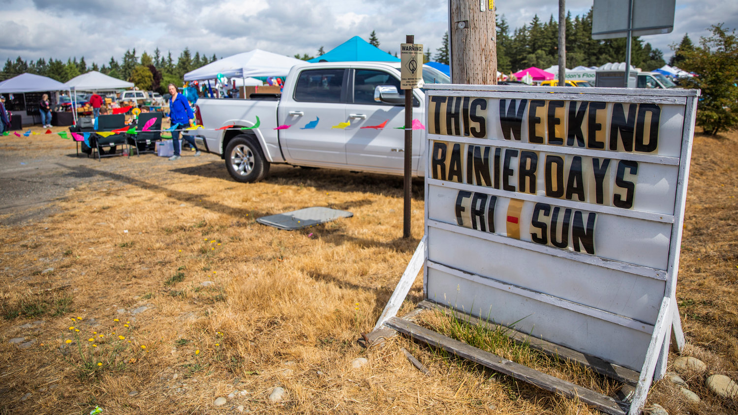Visitors talk to vendors under canopies during Rainier Days on Saturday.