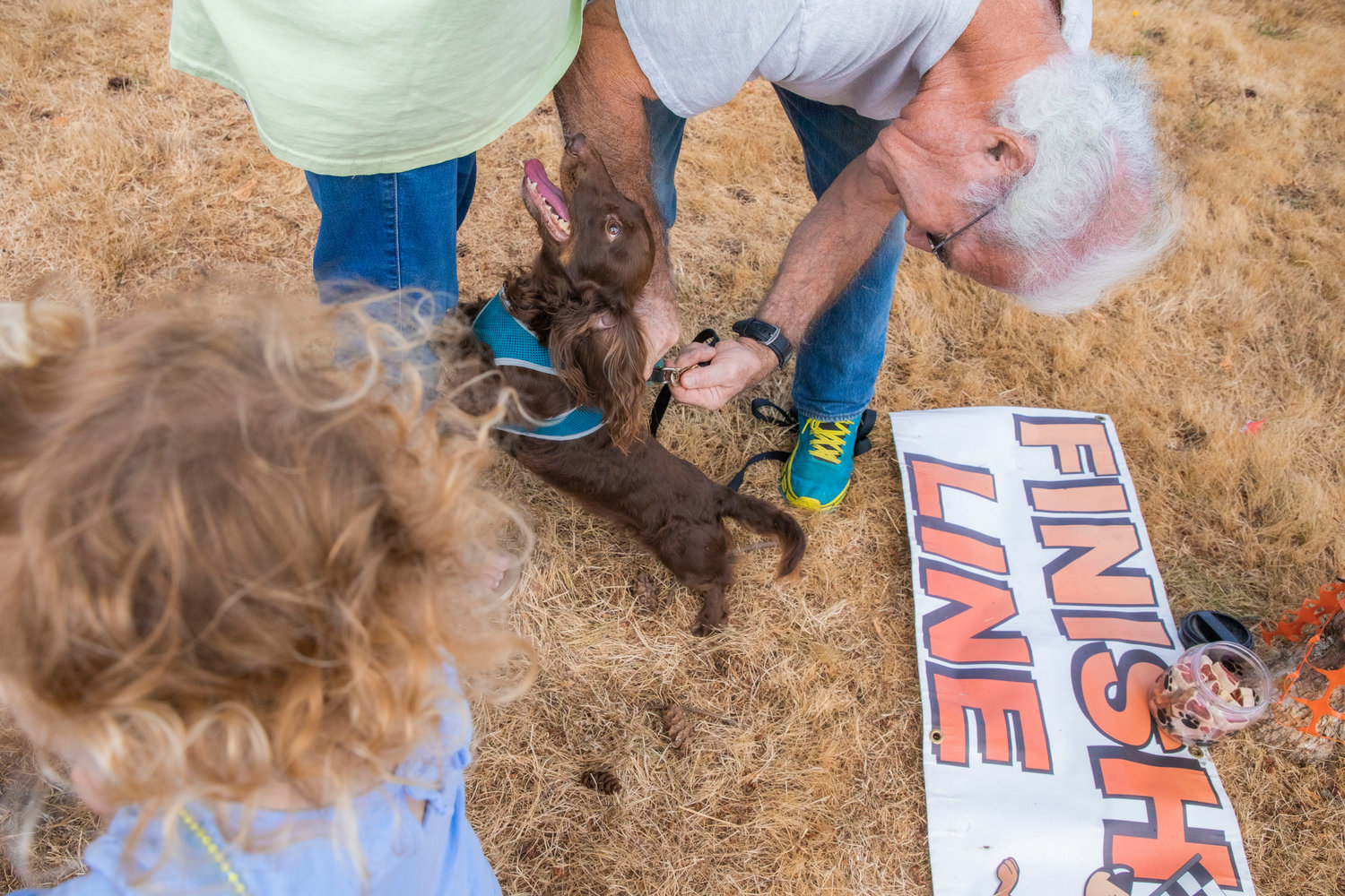 Steve Rowe tries to hook Big Man, a dachshund, on a leash after he won his wiener race Saturday in Rainier.
