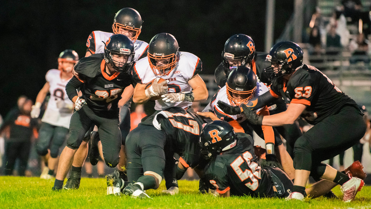 Mountaineers work to stop Napavine junior Cael Stanley (2) as he runs with the football Friday night during a game in Rainier.