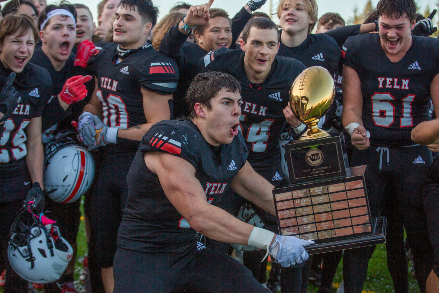 Running back Ray Wright holds up the trophy with other Yelm players after they won the 3A state championship game against Eastside Christian on Saturday in Puyallup on Dec. 3.