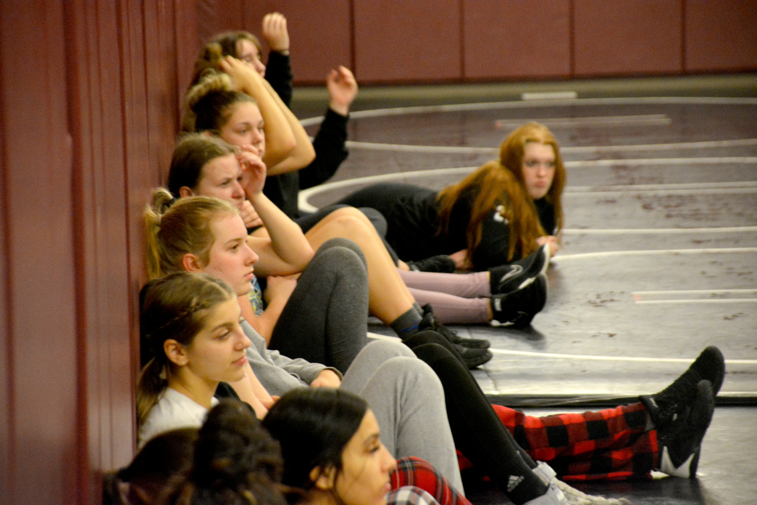 Members of the Yelm girls wrestling team listen to Coach Amy Earley as she speaks about the upcoming postseason.