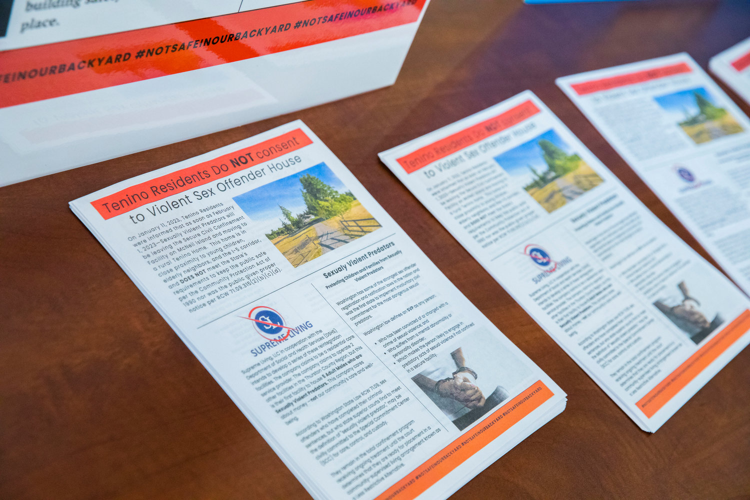 Flyers, with messages in opposition of Supreme Living, sit on display during a meeting with Thurston County Commissioners in Olympia on Tuesday.
