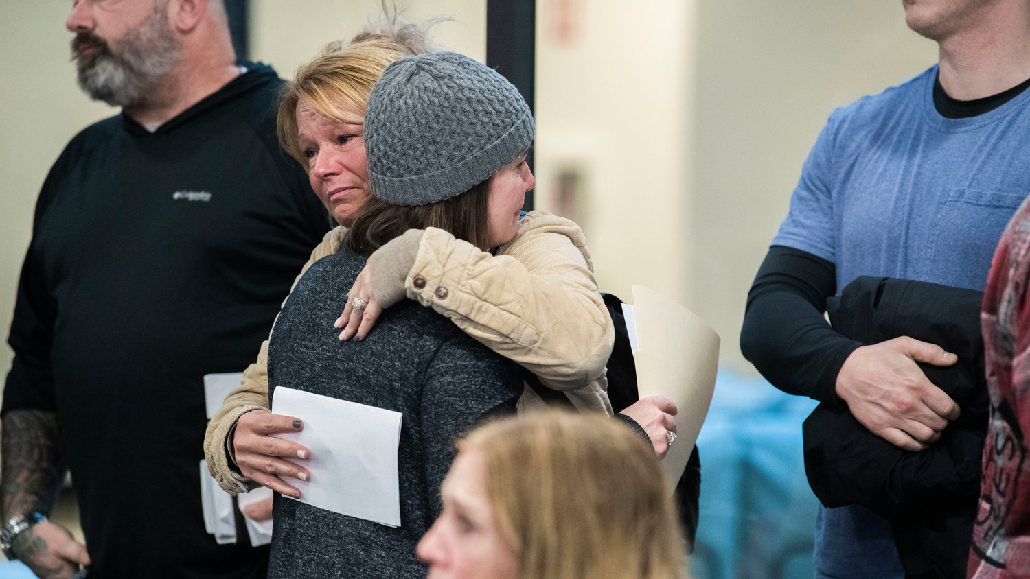 Jennifer Wiens receives an embrace after speaking out against a Supreme Living facility on property she once owned in Tenino.