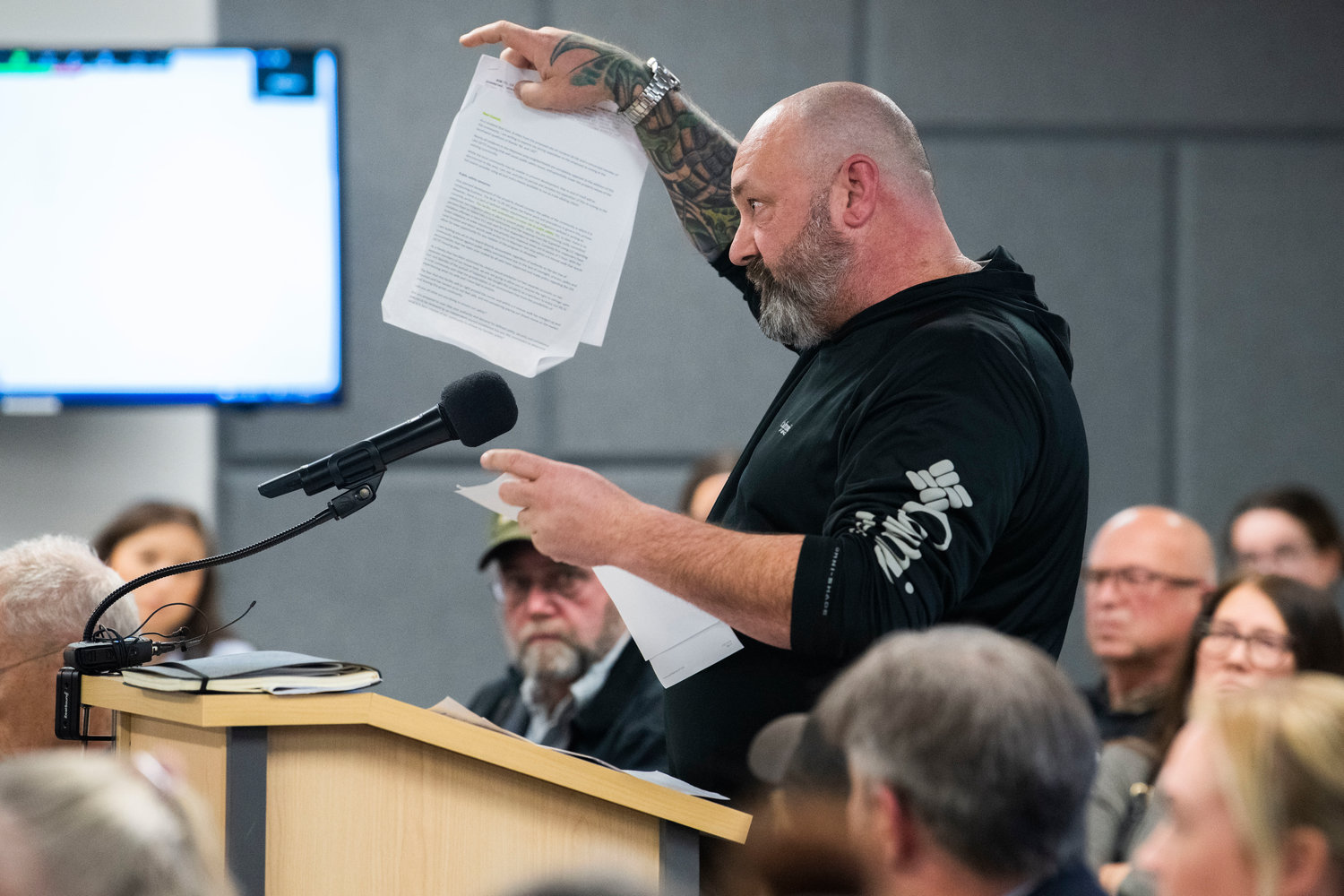 RCWs are held up as Tenino residents speak out in opposition of the Supreme Living facility located at 2813 140th Avenue Southwest in Tenino during a meeting with Thurston County Commissioners in Olympia on Tuesday.