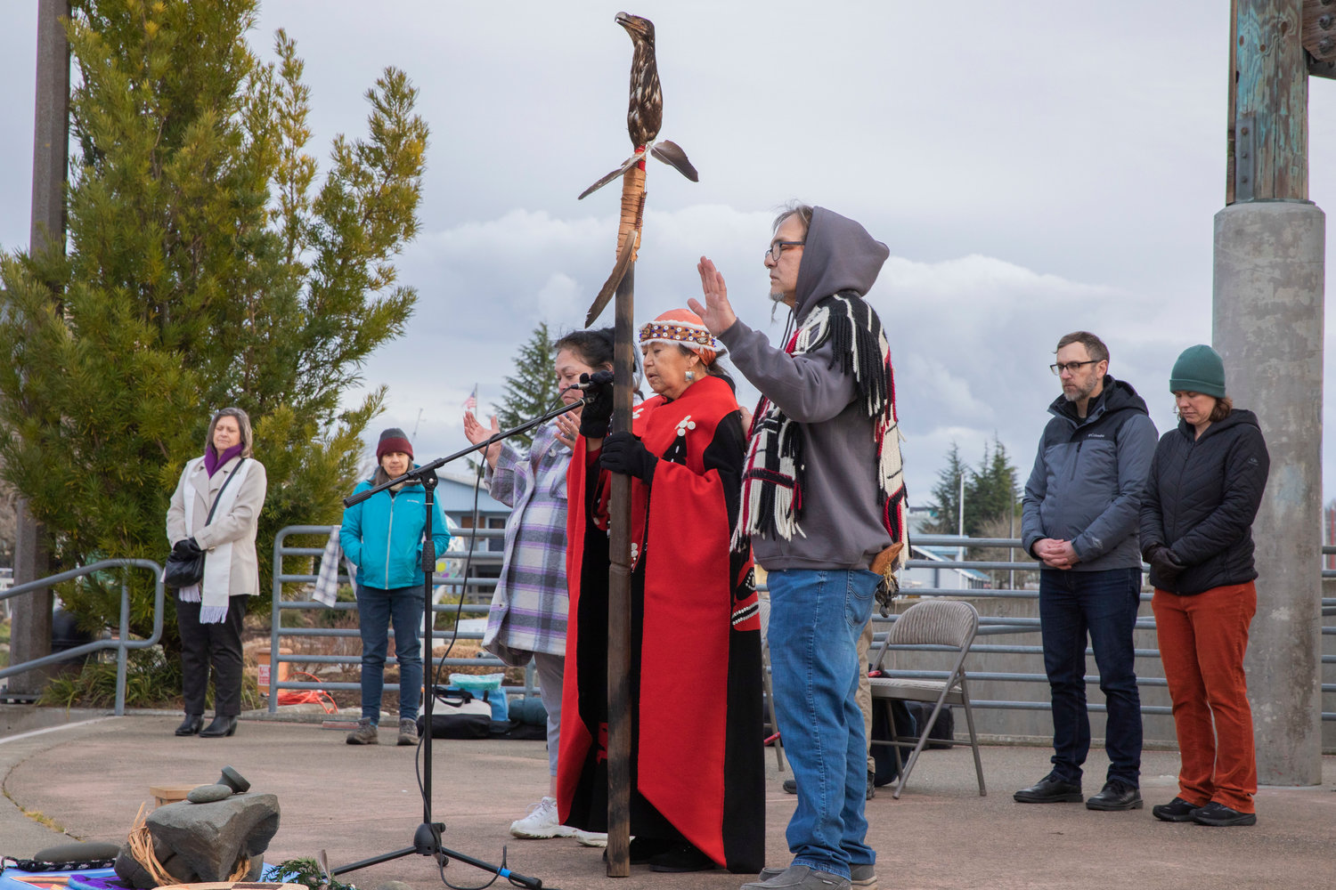 Lisa Johns, of the Squaxin Island Tribe, Mary Leitka, a Hoh Tribal member who works for Nisqually Emergency Management and Freddie Lane of the Lummi Tribal Nation pray with attendees while holding a ritual object, featuring the head of an eagle, at an event hosted by Interfaith Works of Thurston County on Wednesday in Olympia.