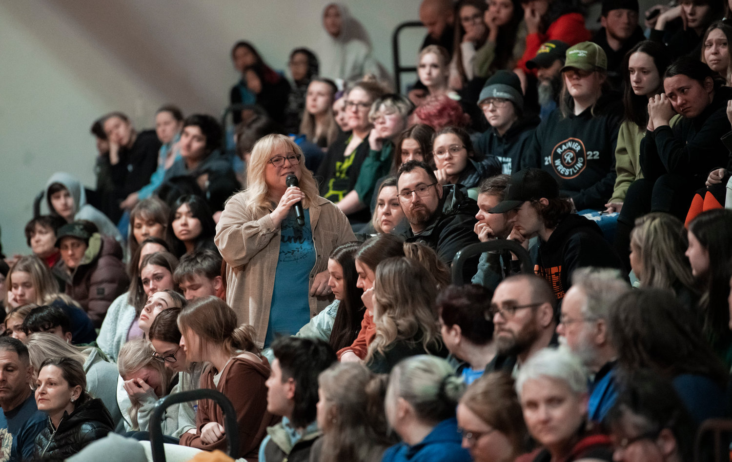 Friends and family members stand up to speak about Jessie Uch during a vigil at Rainier High School on Tuesday.