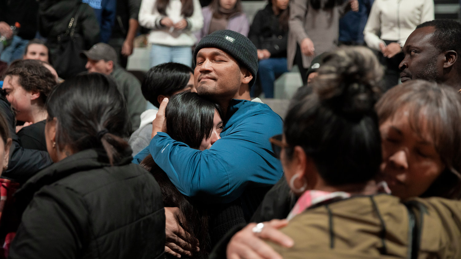 Sopheak Uch, the father of Jessie Uch, receives hugs from friends and family during a vigil for his daughter at Rainier High School on Tuesday.
