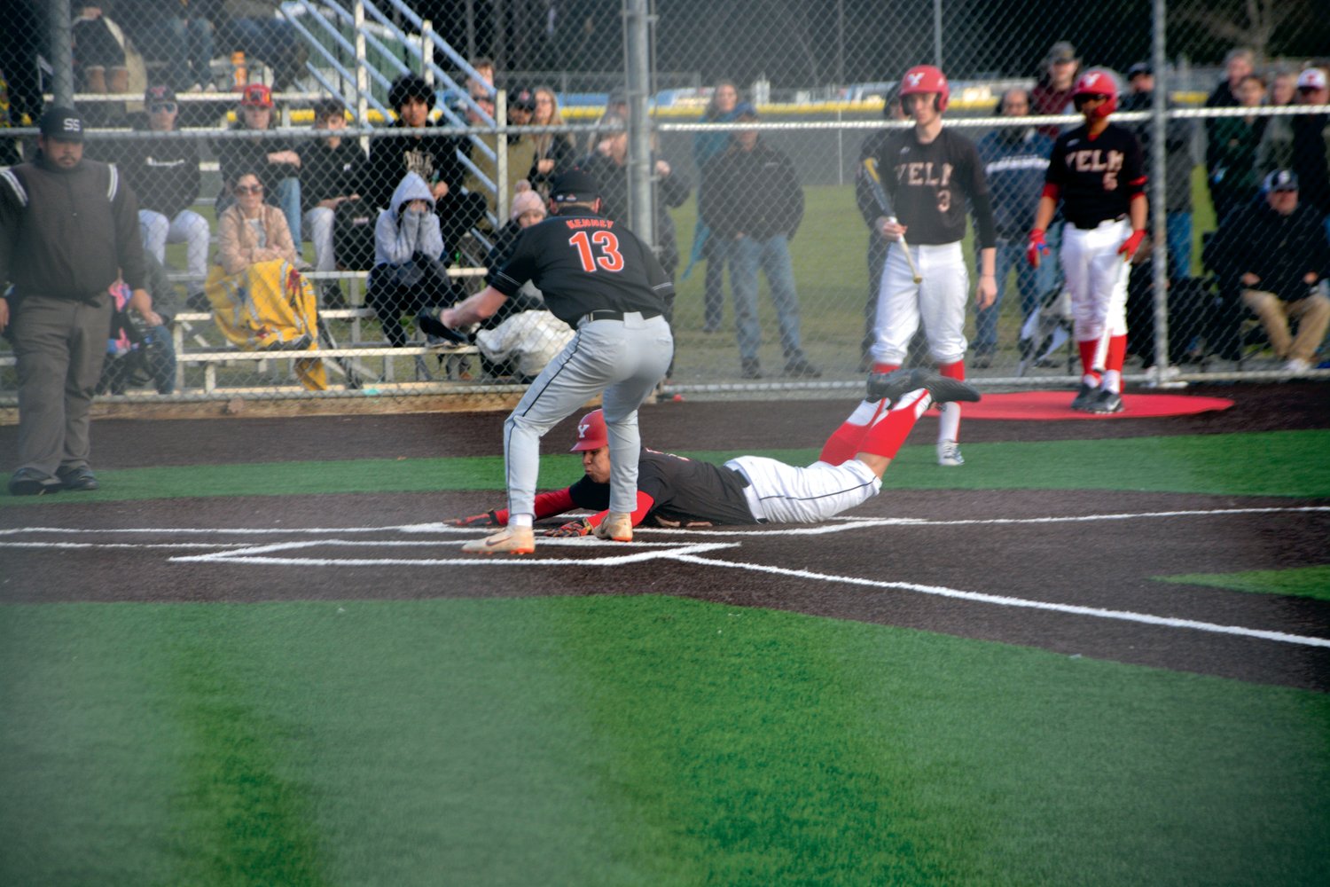 Junior Aaron Youckton, of Yelm,  slides head first into home plate in a game against Rainier on Friday, March 10.