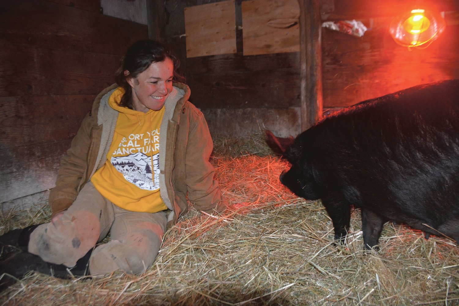 Kate Tsyrklevich smiles as she tends to a female pig that gave birth to seven piglets in this file photo from April.