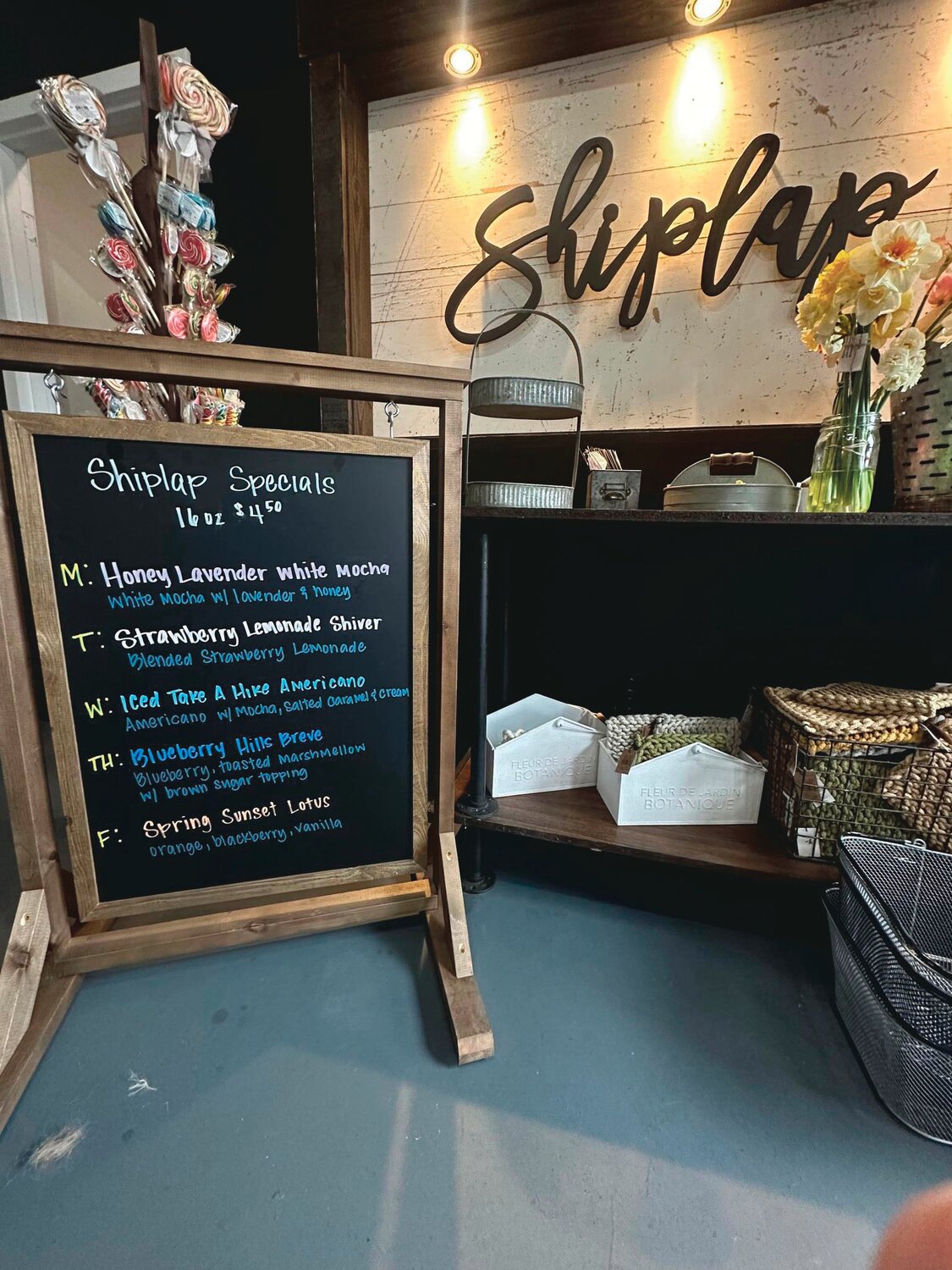 A sign displays Shiplap Shop and Coffee House's specials for the week.