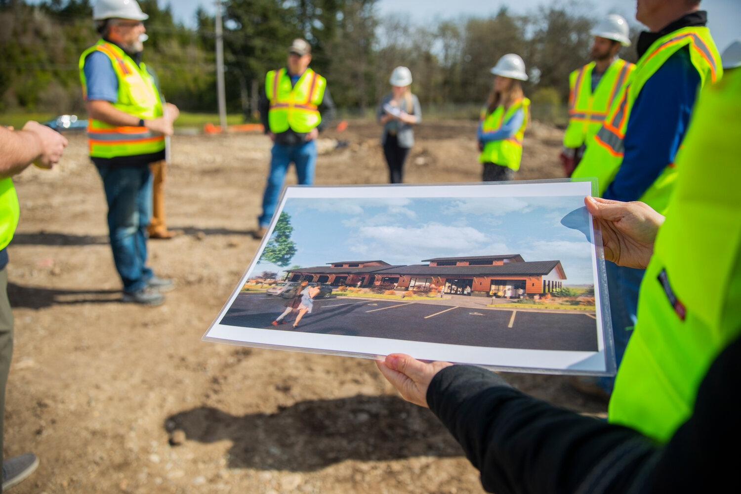 Image renderings are passed around on the construction site of an agricultural park along Old Highway 99 SE in Tenino on Thursday, April 27, 2023.