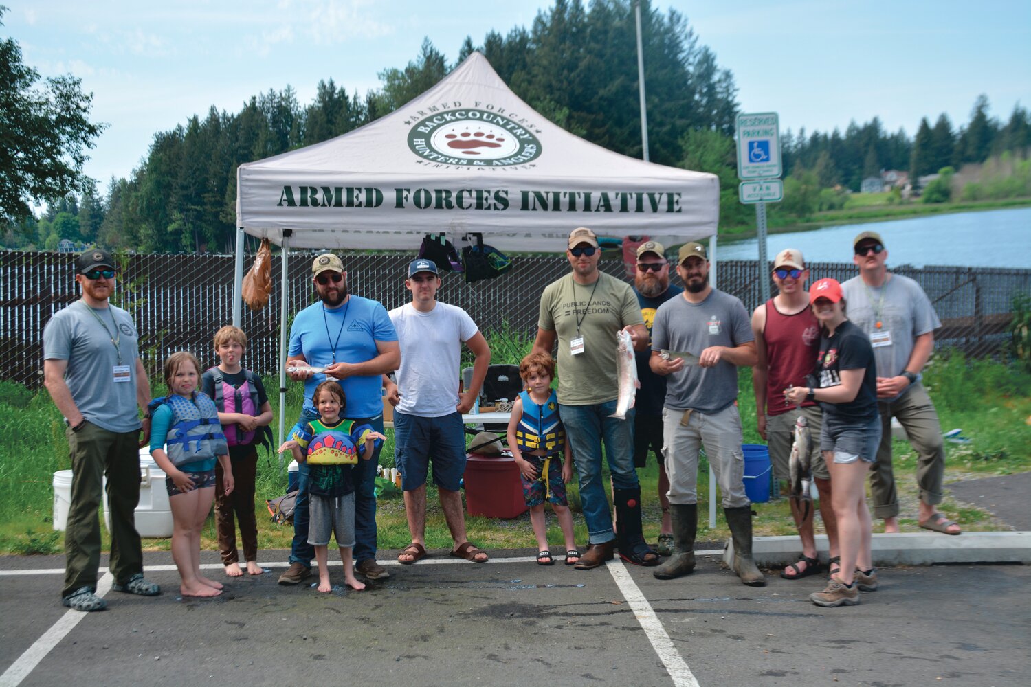 Participants of a Backcountry Hunters and Anglers event hold up the fish they caught at Lake Lawrence on Saturday, May 20.