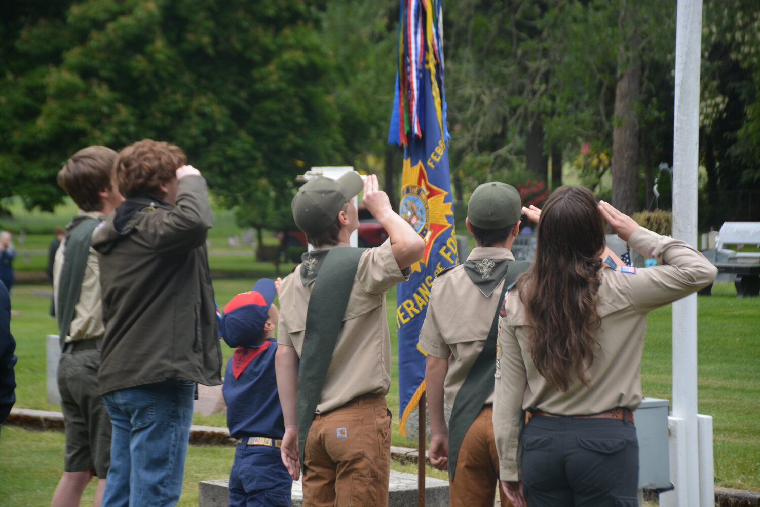 Members of the Boy Scouts of America salute the American Flag at the Memorial Day event at the Yelm Cemetery.