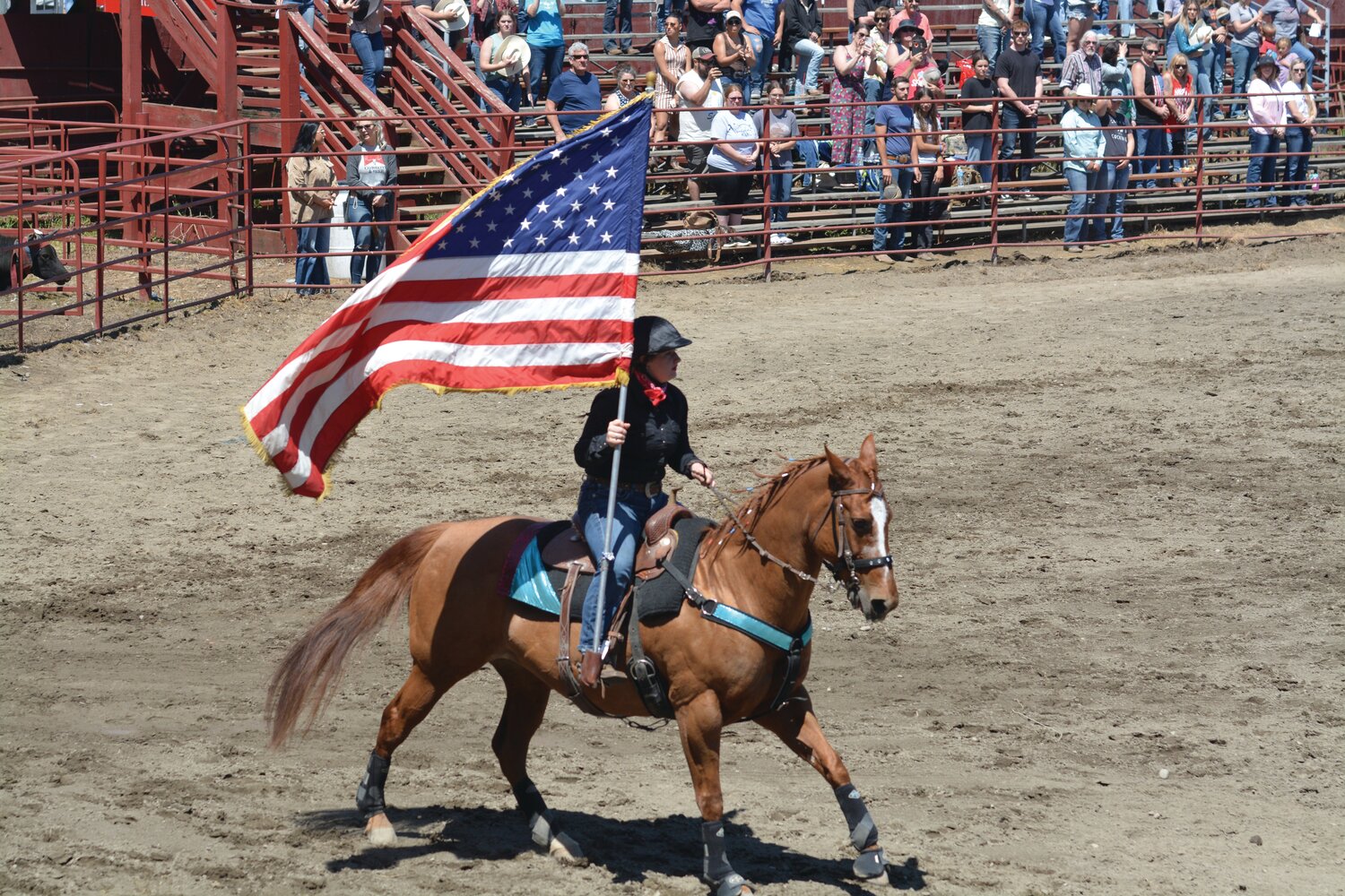 A cowgirl presents the American Flag before the start of the Roy Pioneer Rodeo on June 4.