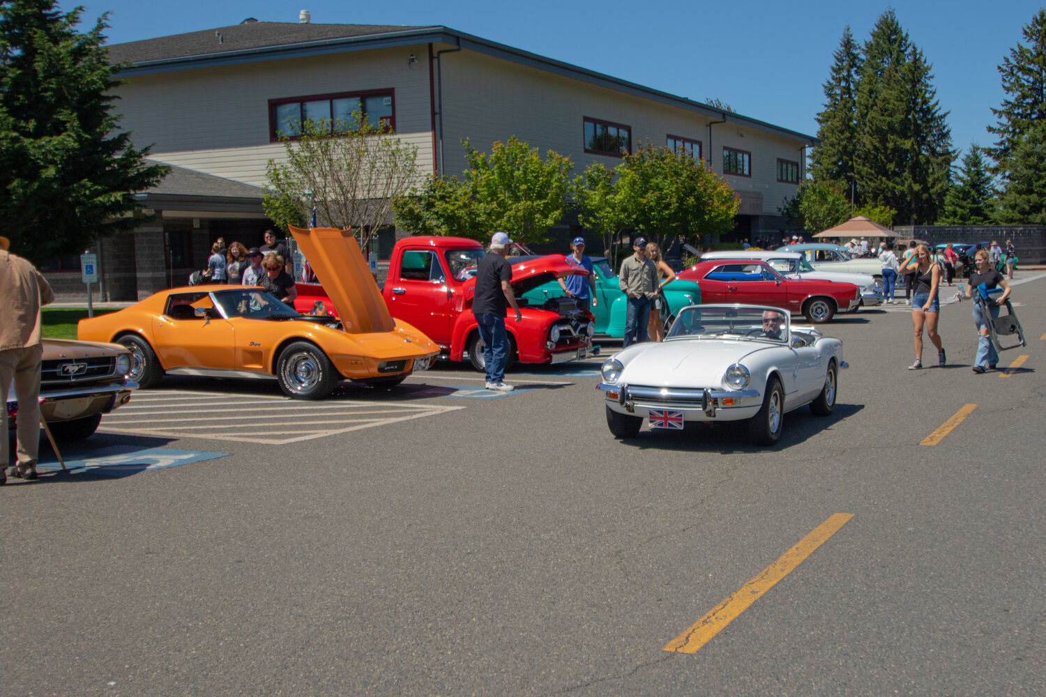 Attendees to Sunday's Yelm High School car show walk around the school's parking lot which was filled with 70 cars.