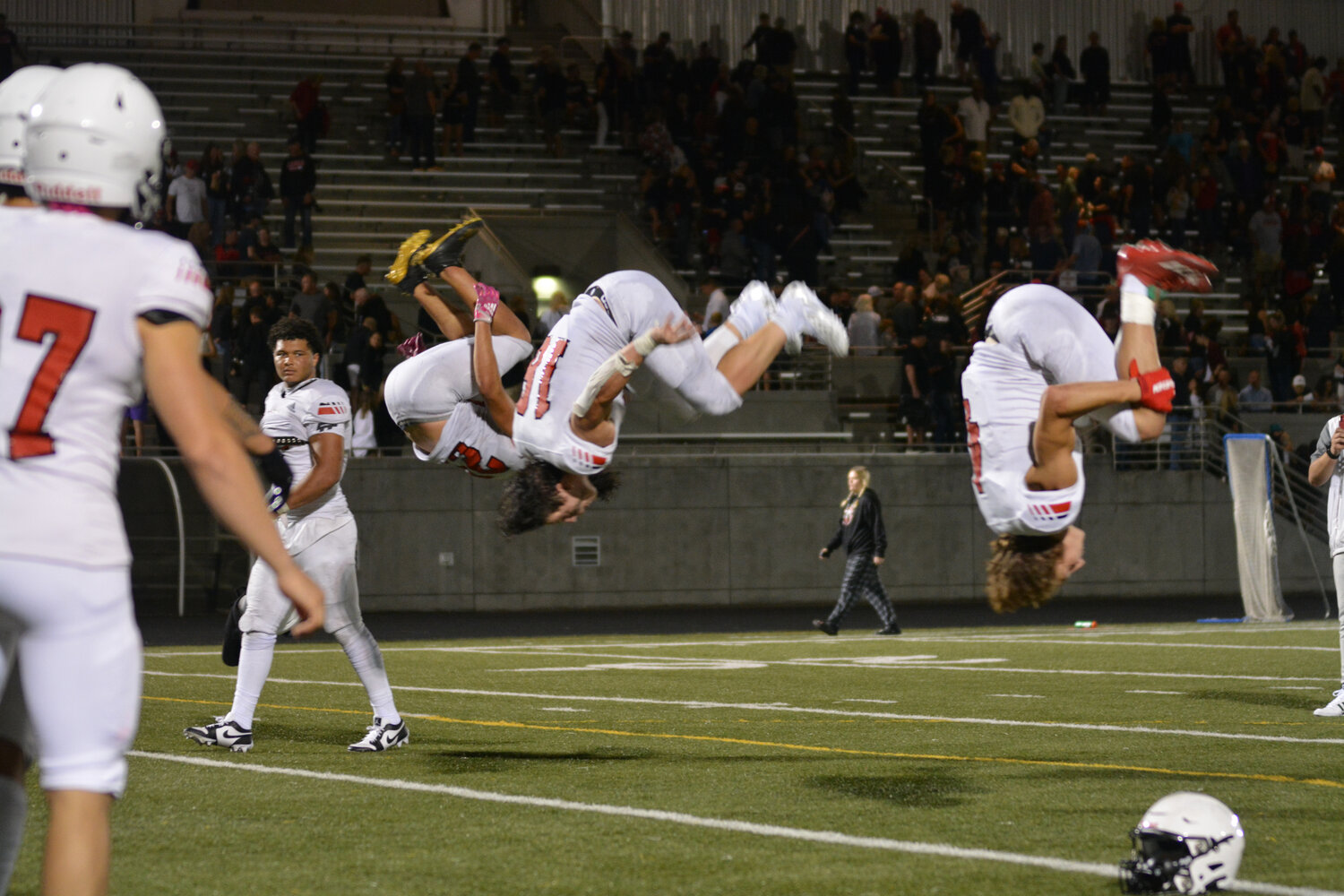 Yelm football athletes Anthony Kiamco (left), Nathan Ford (middle), and Jordan Lasher (right) deliver the tradional “post-game backflip” on Sept. 1 after Yelm beat Camas 8-7.
