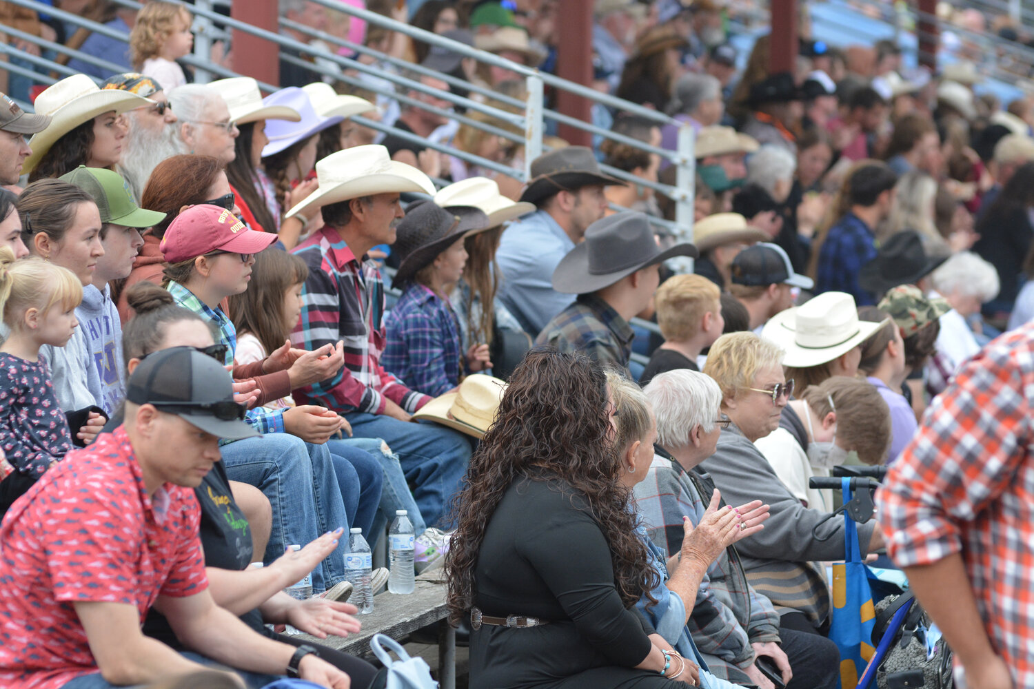 Rodeo attendants applaud a cowboy after a good ride on a buckin’ bronc.