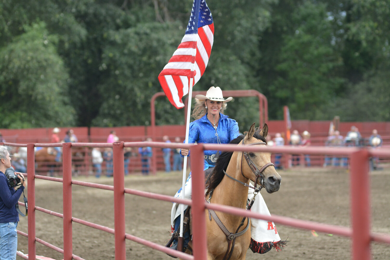 A cowgirl smiles as she presents the Red, White and Blue on Sept. 9 at the Roy Rodeo.
