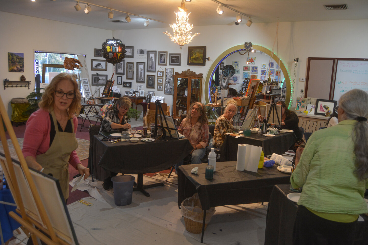 Andrea Levanti (left) displays a painting technique at a Paint & Sip event at InGenius! Gallery & Boutique on Sept. 29.