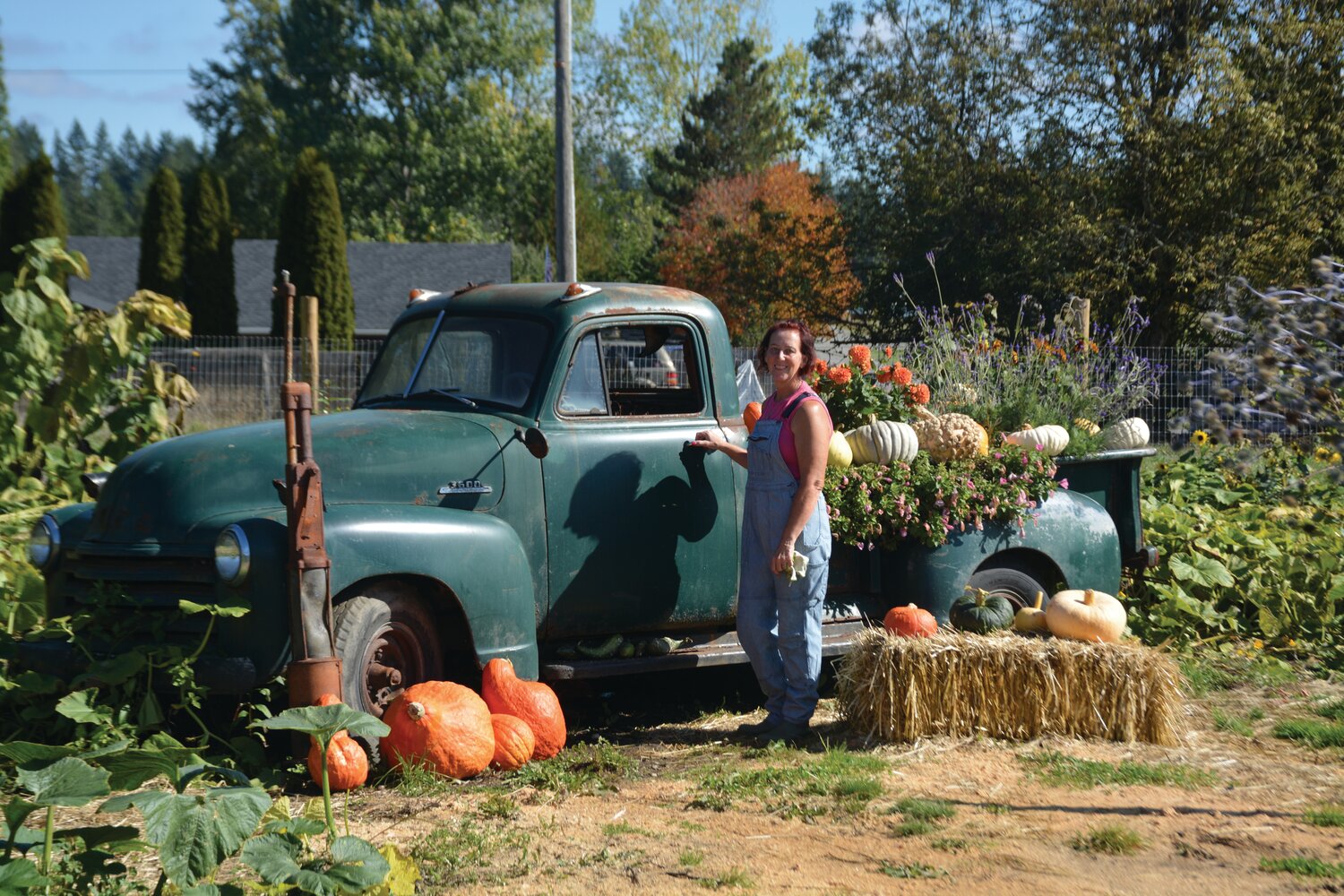 Dawnette Lough, owner of Tranquility Flower Farm, poses in front of a decorative pickup truck at the farm.