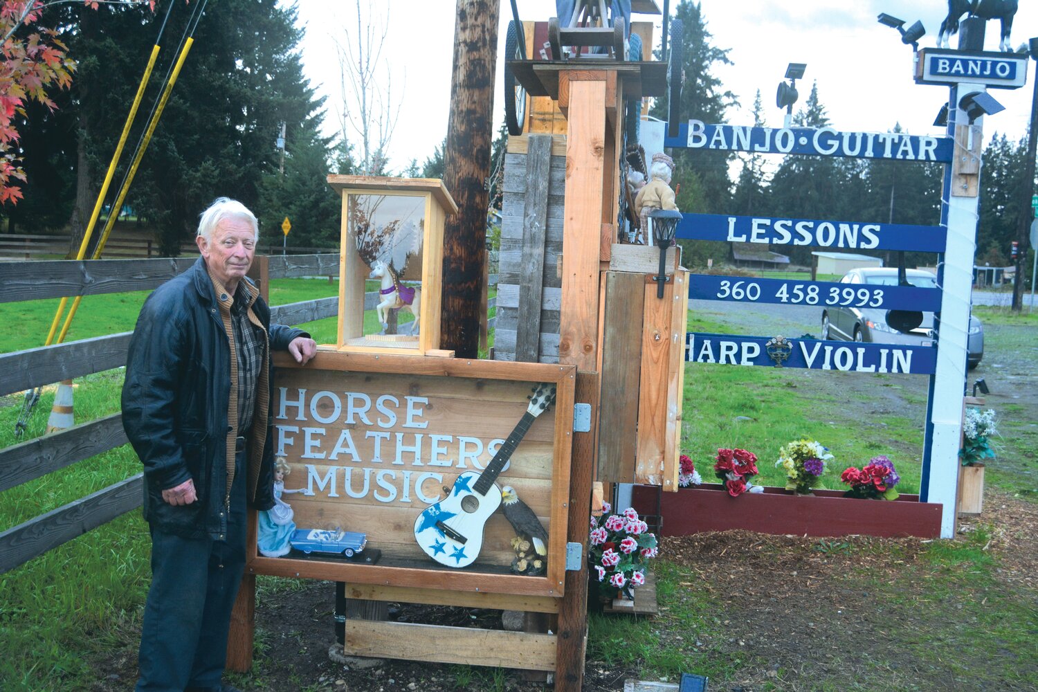 Bob Goodwin stands with his hand-carved sign at his home located at the end of Cook Road, Oct. 24.